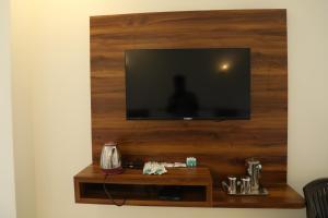 a flat screen tv on a wall with a wooden wall at Hill Woods Yelagiri in Yelagiri