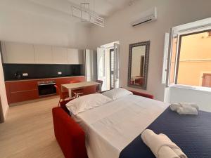 a bedroom with a large bed and a kitchen at Vico Rosso - Milù Holidays La Maddalena in La Maddalena