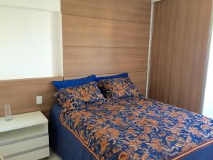 een slaapkamer met een blauw bed en een houten hoofdeinde bij Apartamento Sol e Mar Maceió in Maceió +20 foto's