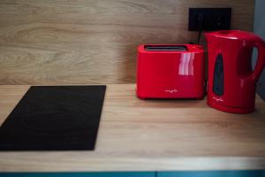 a red toaster sitting on top of a wooden counter at KNB City Suites in Odorheiu Secuiesc +104 photos