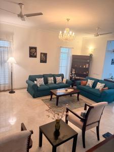 a living room with a blue couch and a table at Luxre Homes - Villa in Koramangala in Bangalore