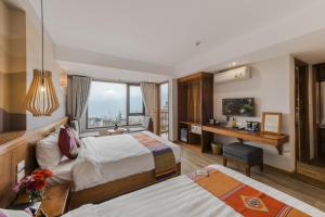 a hotel room with two beds and a desk at Sapa Panorama Hotel in Sapa