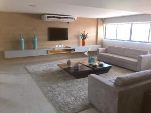 een woonkamer met een bank en een tv bij Apartamento Sol e Mar Maceió in Maceió