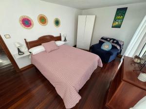 a bedroom with a bed and a chair in it at La casa del Rubio in Pedreña