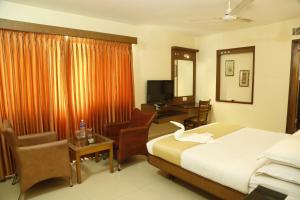 a hotel room with a bed and a desk at HOTEL GRAND PLAZzA in Coimbatore