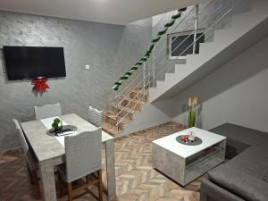 a living room with a table and a tv and stairs at Drinski sjaj in Ljubovija