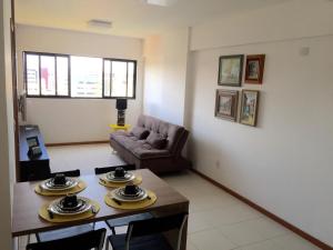 een woonkamer met een tafel en een bank bij Apartamento Sol e Mar Maceió in Maceió