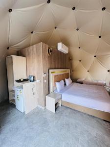 a bedroom with a large bed in a tent at DESERT HELO lUXURY CAMP & TOUR in Wadi Rum