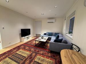 a living room with a blue couch and a tv at Modern apartment in Drammen