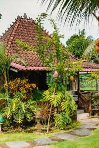 a house with a bunch of plants in front of it at Nauna Villa Bali in Ubud