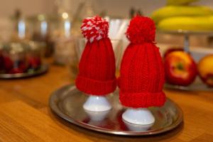 two red knitted santa hats on a silver plate at Haus Geistmeier in Lippstadt