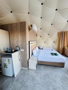 a bedroom with a large bed in a tent at DESERT HELO lUXURY CAMP & TOUR in Wadi Rum