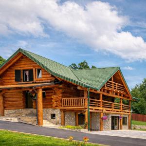 a log cabin with a green roof at Luxury Family Lodge - Pool, Spa & Tennis Paradise in Gospić