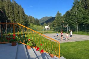 a group of people playing basketball on a basketball court at Črjanski Raj in Črna na Koroškem