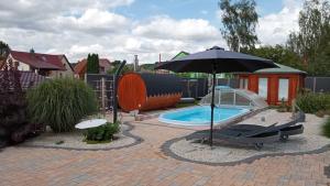 a patio with an umbrella and a swimming pool at Ferienhäuser Radebeul "Apartment Altkötzschenbroda" in Radebeul