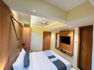 a hotel room with a bed and a flat screen tv at Hotel Comfort Castle in Mumbai