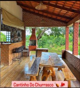 an outdoor patio with a wooden table and a stove at Rancho Corumba VI in Alexânia
