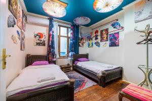 two beds in a room with paintings on the walls at Central House for up to 20 Guests Entire Place in Sofia