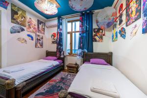 two twin beds in a room with umbrellas on the walls at Central House for up to 20 Guests Entire Place in Sofia