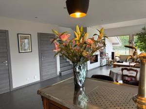 a vase with flowers on a table in a living room at L 'Écrin du Lac et Parkings in Veyrier-du-Lac