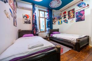 two beds in a room with paintings on the walls at Central House for up to 20 Guests Entire Place in Sofia