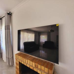 a living room with a large flat screen tv on a wall at Familyfriendlyhome4u in Bulawayo