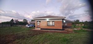 a small house in a yard with a car parked at Familyfriendlyhome4u in Bulawayo