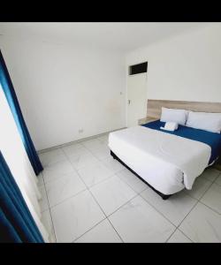 a bedroom with a large white bed with blue sheets at Familyfriendlyhome4u in Bulawayo
