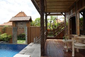 a villa with a swimming pool and a house at Nauna Villa Bali in Ubud