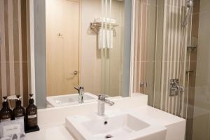 a bathroom with a sink and a mirror at Hotel Tour Incheon Airport Hotel & Suites in Incheon +14 photos