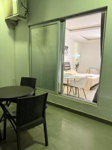 a room with a large window and a table and chairs at Precious Pavilion - Single Rooms in Abuja