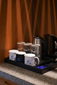 a tray with coffee mugs and cups on a counter at Hotel Tour Incheon Airport Hotel & Suites in Incheon
