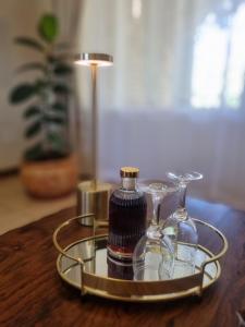a tray with two bottles and glasses on a table at Bultpark Apartment in Potchefstroom