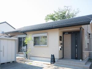 a small house with a door and a garage at お宿 春Haru in Muromoto