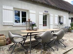 a table and chairs in front of a house at Chez Mémé Delphine in Moutier-Malcard