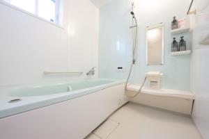 a white bathroom with a tub and a toilet at お宿 春Haru in Muromoto +17 photos