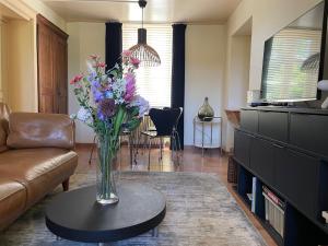 a living room with a vase of flowers on a table at Chez Mémé Delphine in Moutier-Malcard