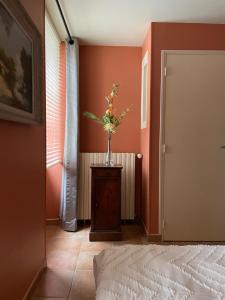 a bedroom with a vase of flowers on a table at Chez Mémé Delphine in Moutier-Malcard
