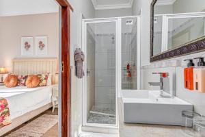 a bathroom with a shower and a sink and a bed at Caledon 23 Guest House in George +60 photos