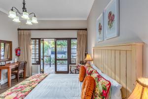 a bedroom with a large bed and a desk at Caledon 23 Guest House in George
