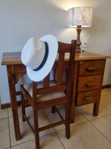a hat sitting on a chair next to a desk at Bultpark Apartment in Potchefstroom