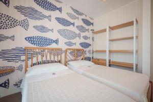 a bedroom with two beds with blue fishes on the wall at Casa Costa Sud in Bari