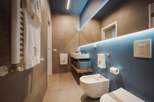 a bathroom with a white toilet and a blue wall at Casa Costa Sud in Bari +63 photos