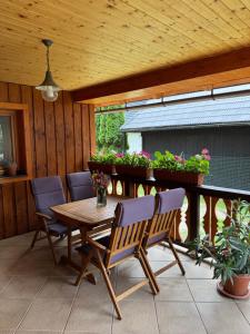 a wooden table and chairs on a patio with plants at Drevenica MATAJKA in Kvačany