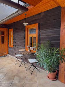 a patio with two chairs and a table on a wooden wall at Drevenica MATAJKA in Kvačany