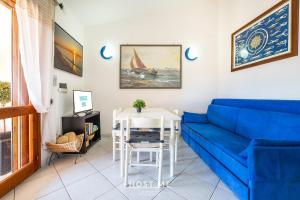 a living room with a blue couch and a table at Terrazza 12 - Free Wifi in Costa Rei