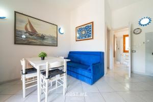 a living room with a blue chair and a table at Terrazza 12 - Free Wifi in Costa Rei +25 photos