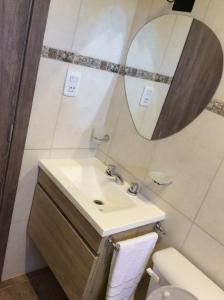 a bathroom with a sink and a mirror at El Rincon del Descanso in General Alvear +14 photos