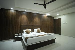a bedroom with a large bed with a wooden wall at Hotel Jay Palace in Kota