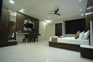 a hotel room with a bed and a desk at Hotel Jay Palace in Kota